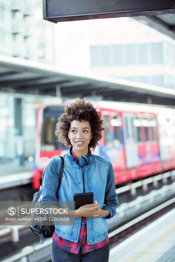 Woman holding digital tablet in train station