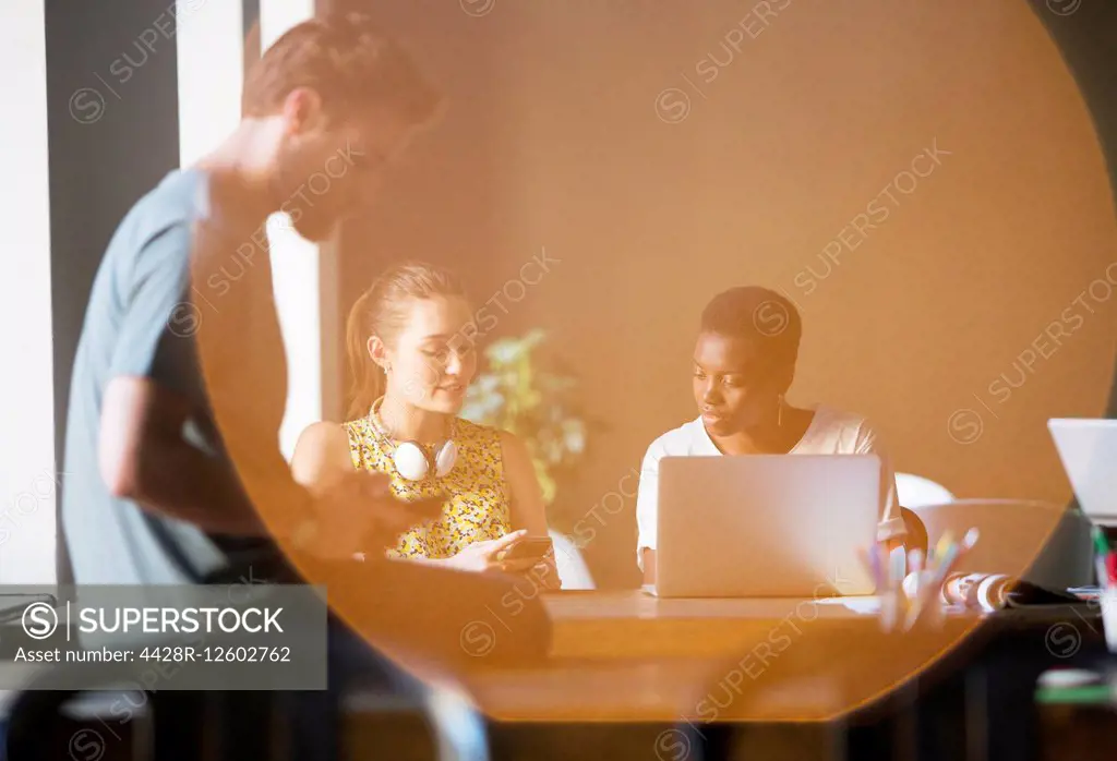 Lens flare over creative business people working in office