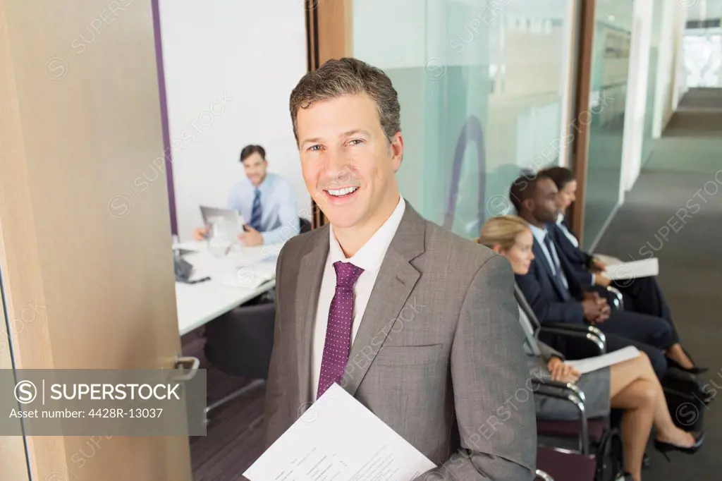Businessman smiling in office, London, UK