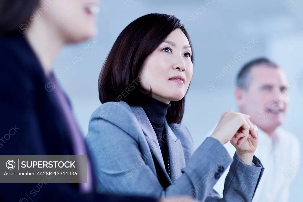 Attentive serious businesswoman listening in meeting