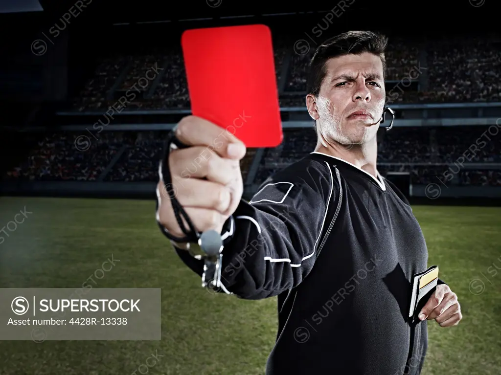 Referee flashing red card on soccer field