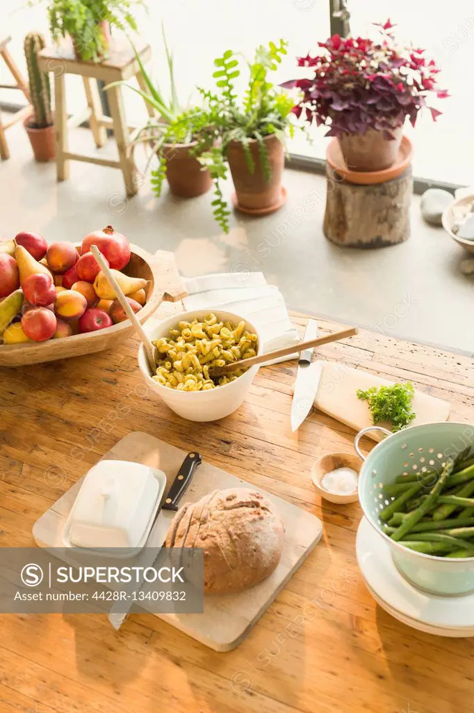 Pasta, fruit, bread, butter and asparagus on dining table