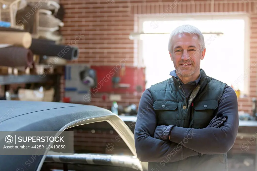 Portrait confident mechanic in auto repair shop