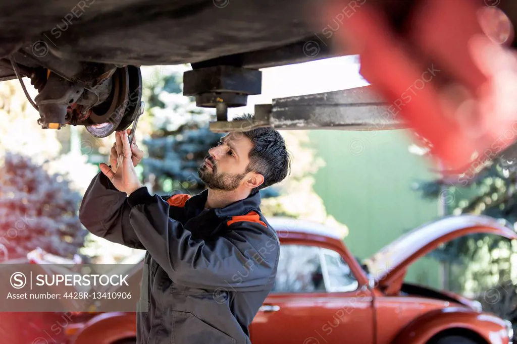 Mechanic underneath car fixing brakes