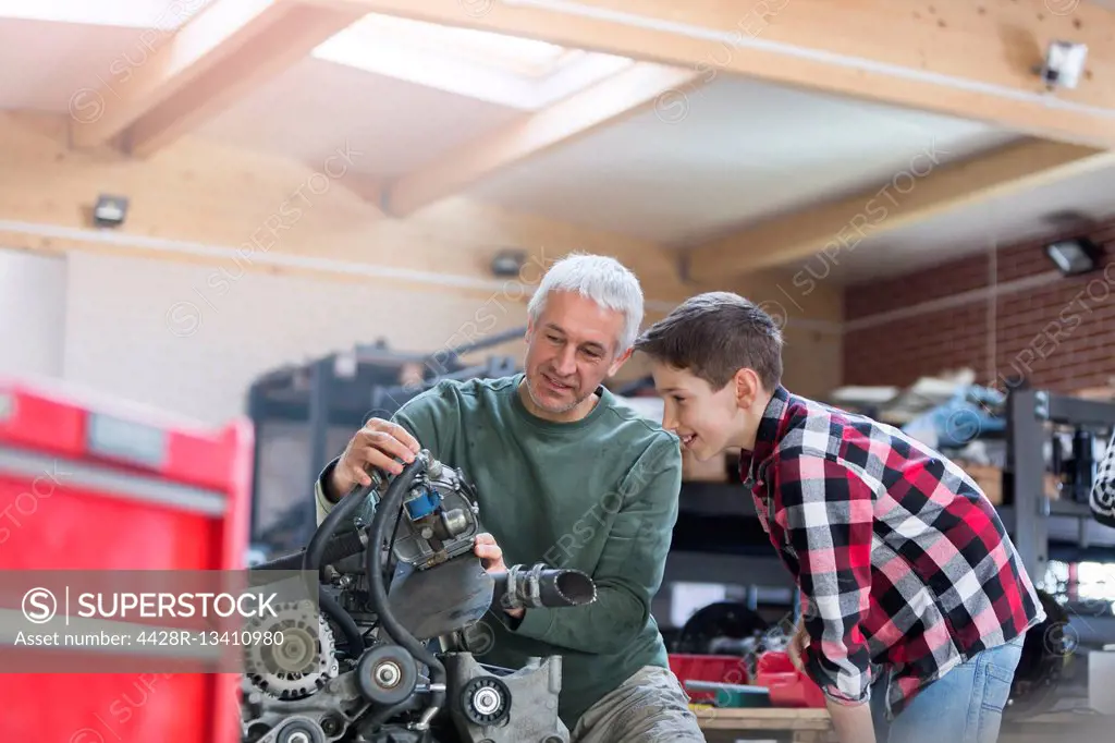 Father and son rebuilding engine in auto repair shop