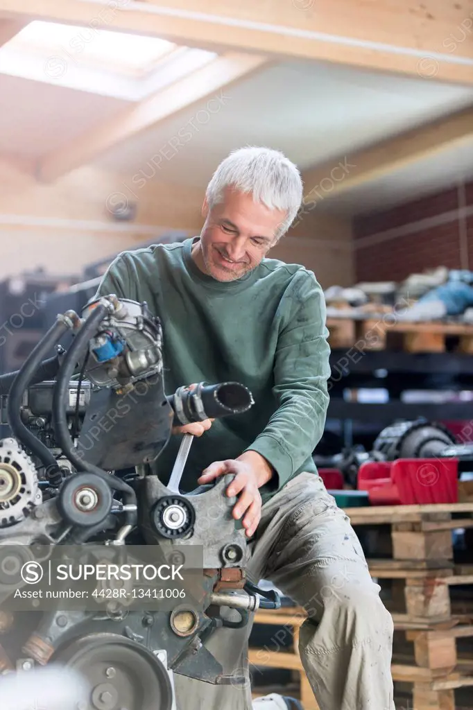 Mechanic rebuilding engine in auto repair shop