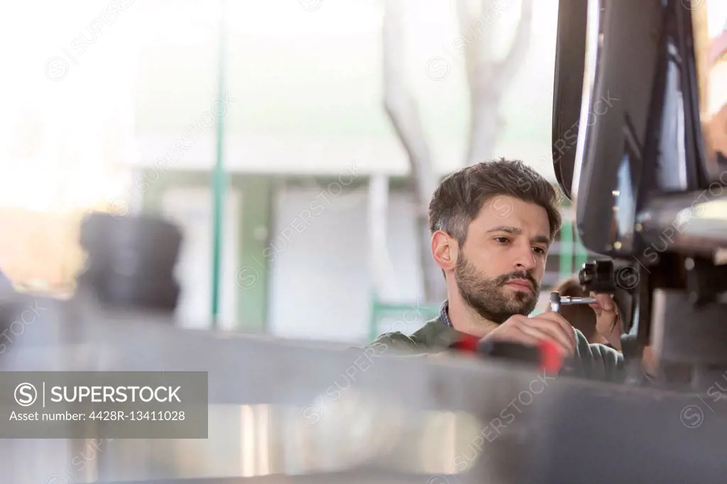 Focused mechanic repairing car in auto repair shop