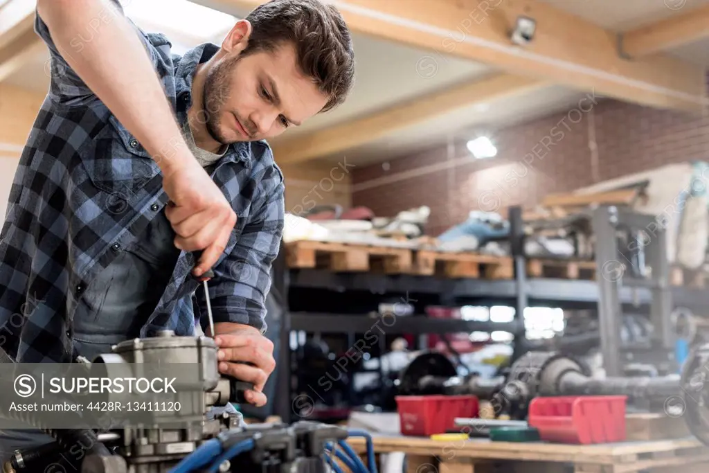 Mechanic fixing car engine in auto repair shop