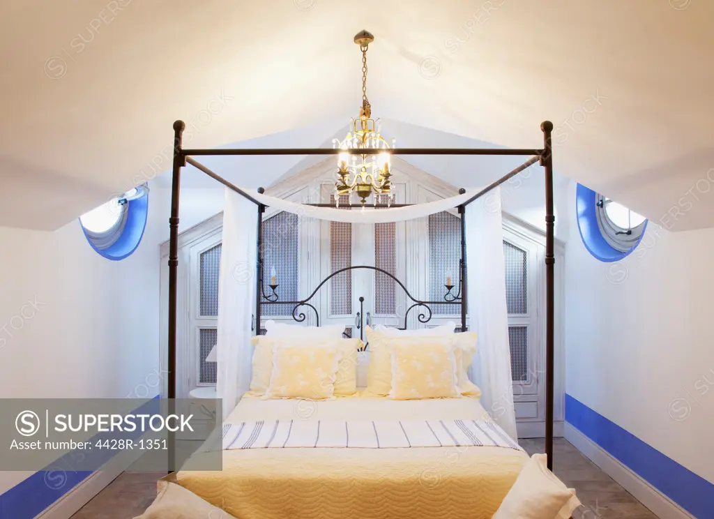 Spain, Chandelier over four poster bed in luxury bedroom