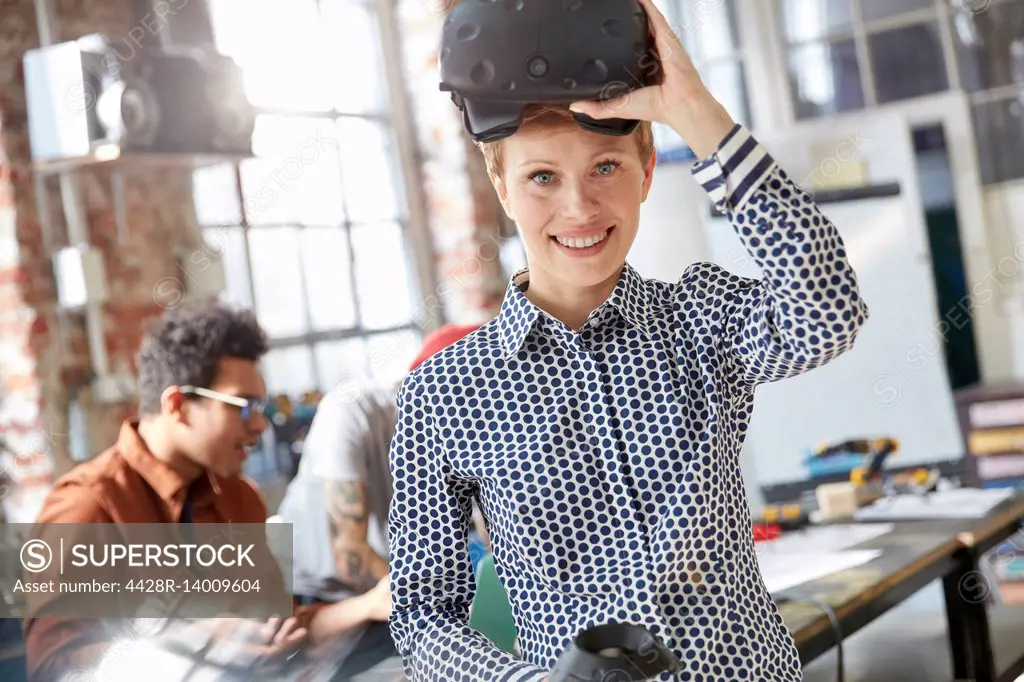 Portrait smiling female computer programmer wearing virtual reality simulator glasses