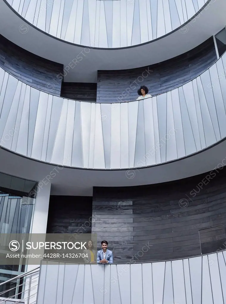 Portrait business people standing on architectural, modern office atrium balconies