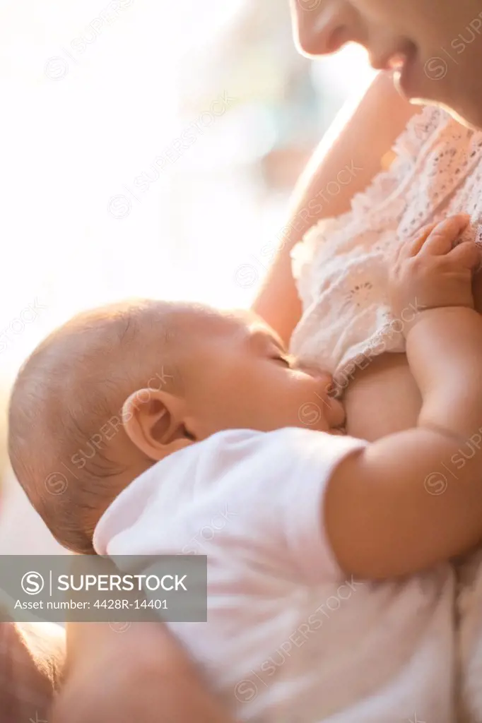 Mother breast-feeding baby boy, London, UK