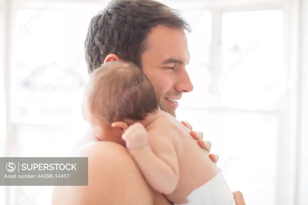 Father holding baby girl, London, UK