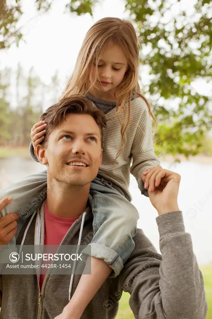 Cape Town, Father carrying daughter on shoulders at lakeside