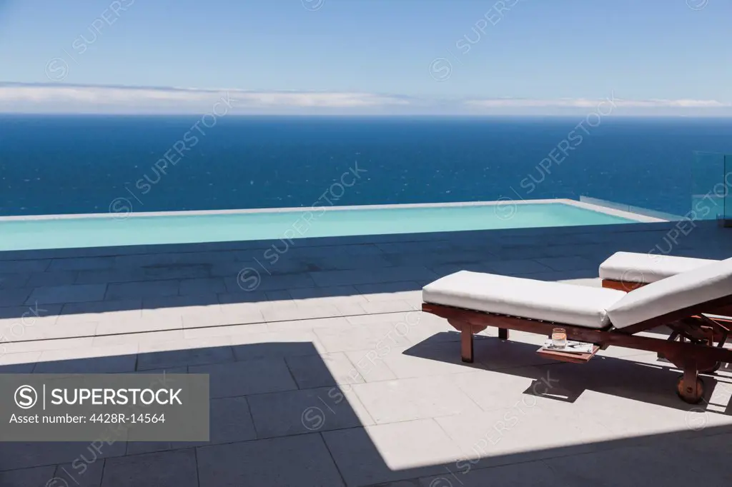 Lounge chairs and infinity pool overlooking ocean, Cape Town, South Africa