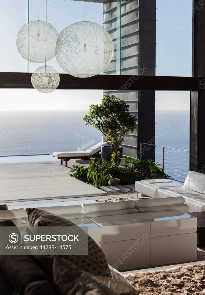 Sofas and tables in modern living room overlooking ocean, Cape Town, South Africa