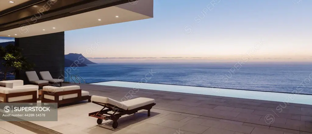 Modern patio and infinity pool overlooking ocean at sunset, Cape Town, South Africa