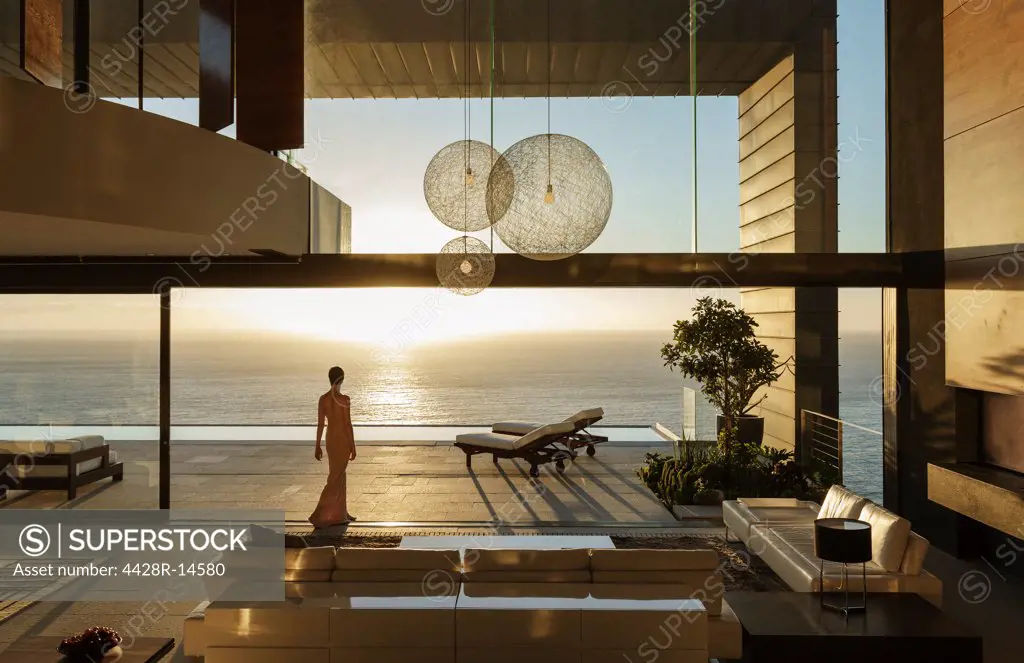 Woman in modern house overlooking ocean, Cape Town, South Africa