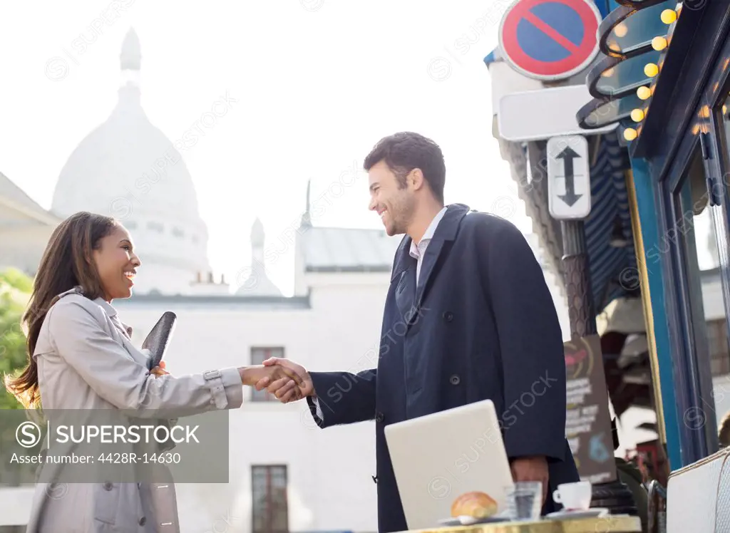 Business people shaking hands on city street, Paris, France