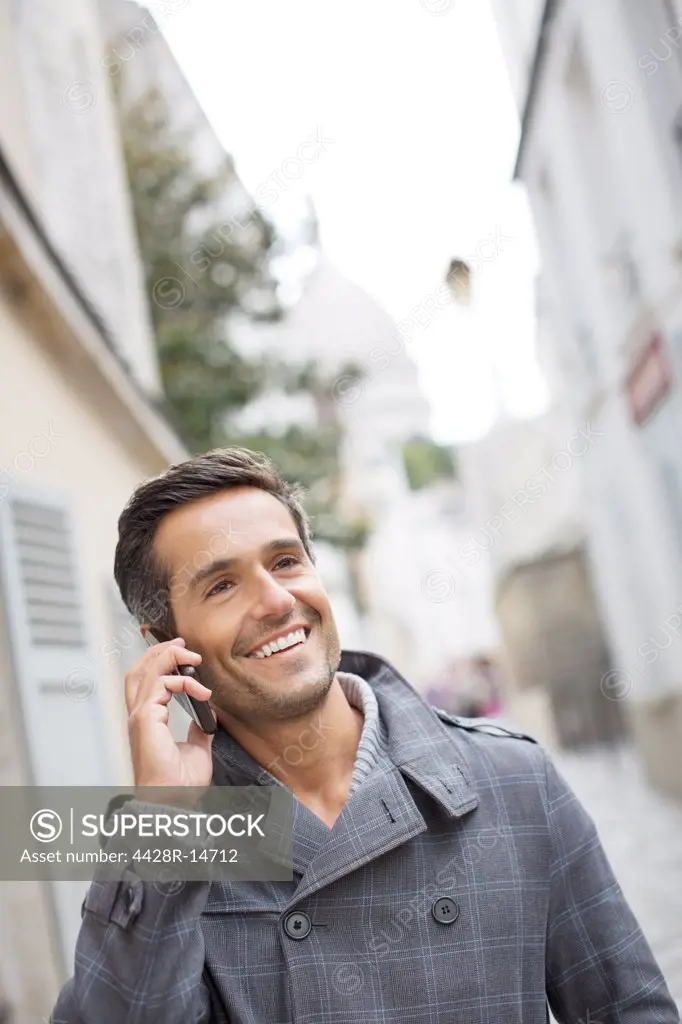 Businessman talking on cell phone outdoors, Paris, France