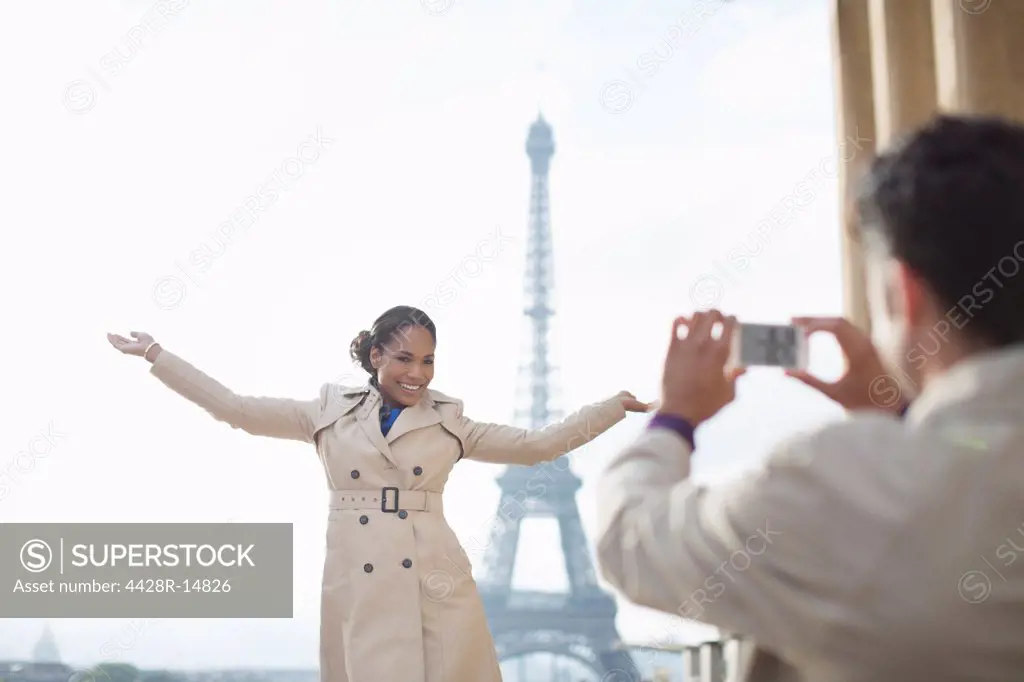 Man photographing girlfriend in front of the Eiffel Tower, Paris, France, Paris, France