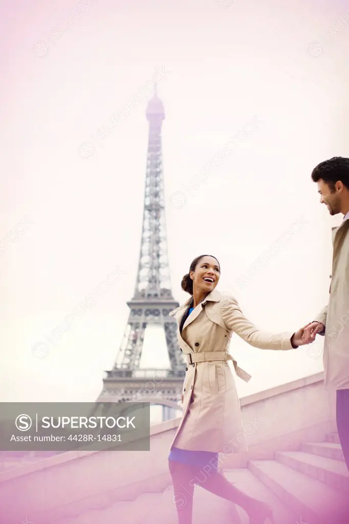 Couple descending stairs by Eiffel Tower, Paris, France, Paris, France