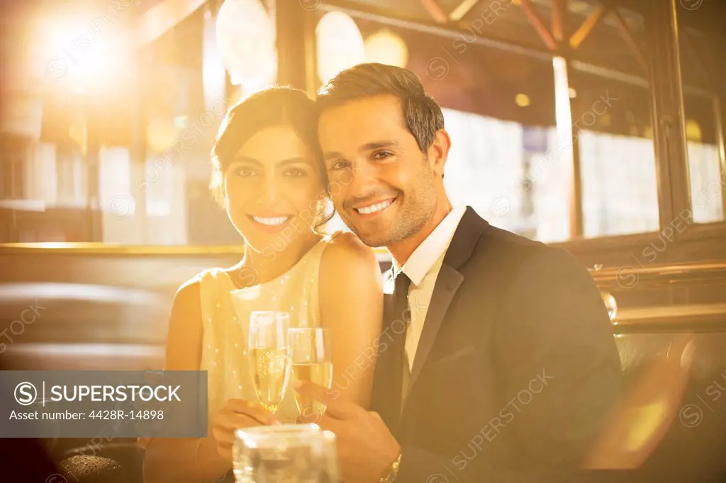 Couple toasting champagne flutes in restaurant, Paris, France