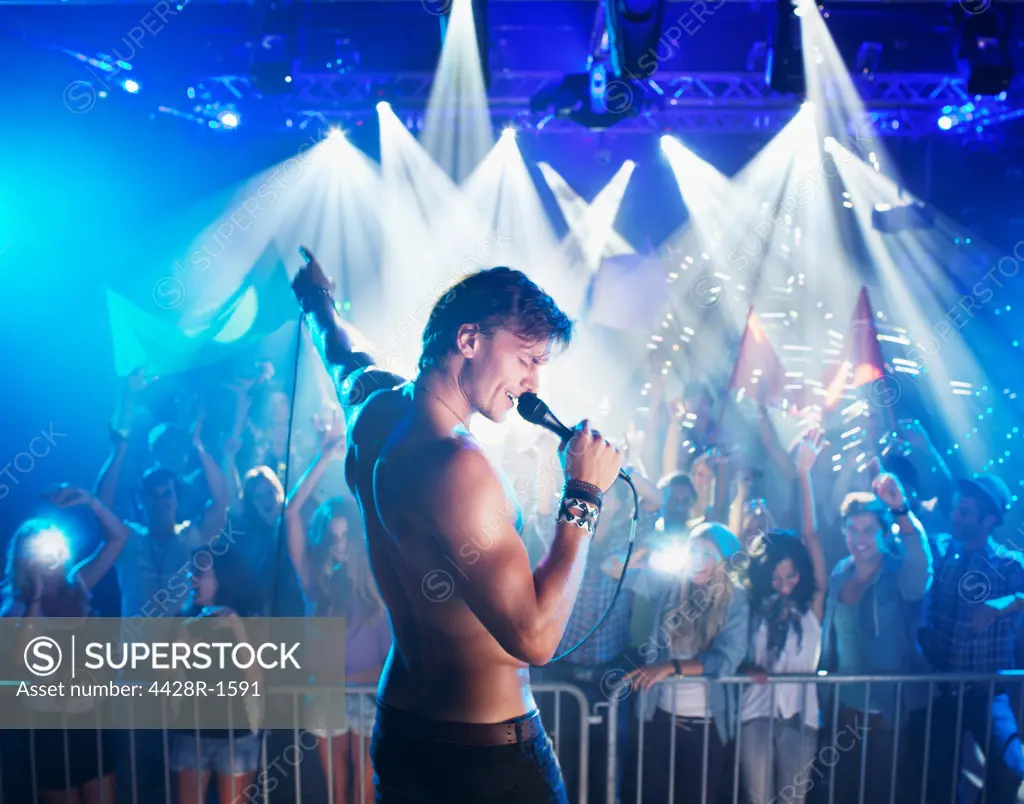 Cape Town, Bare chested singer performing on stage with crowd in background