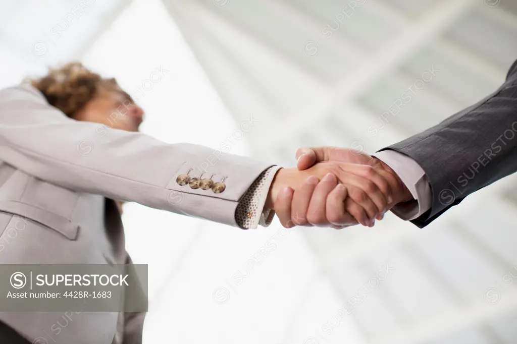 Spain, Close up of businessman and businesswoman shaking hands