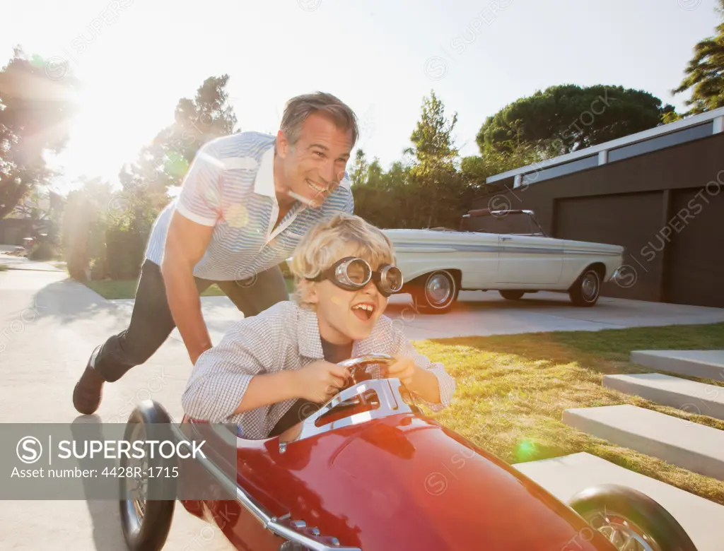 Los Angeles, USA, Father pushing son in go cart