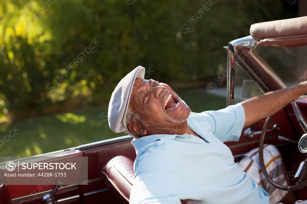 Los Angeles, USA, Laughing older man driving convertible