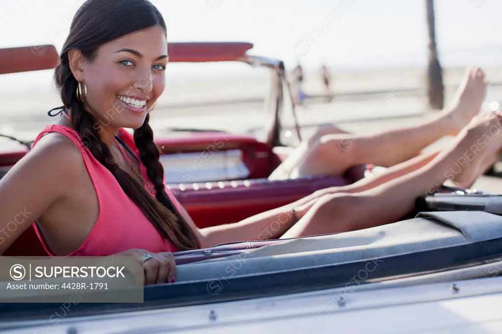 Los Angeles, USA, Smiling woman relaxing in convertible