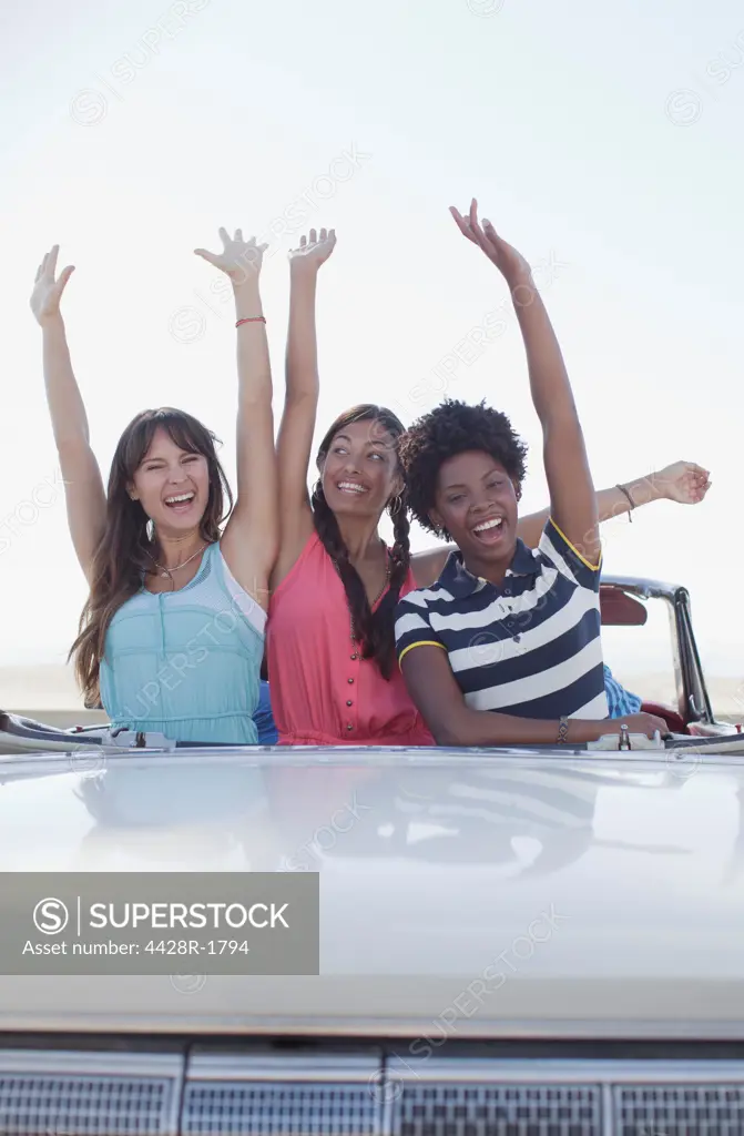 Los Angeles, USA, Smiling women cheering in convertible