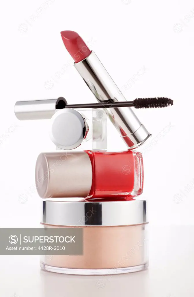 Lipstick, mascara and fingernail polish stacked on moisturizer jar