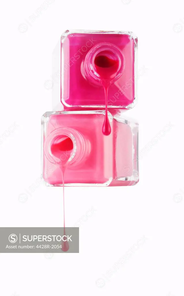 Close up of pink fingernail polish dripping from bottles