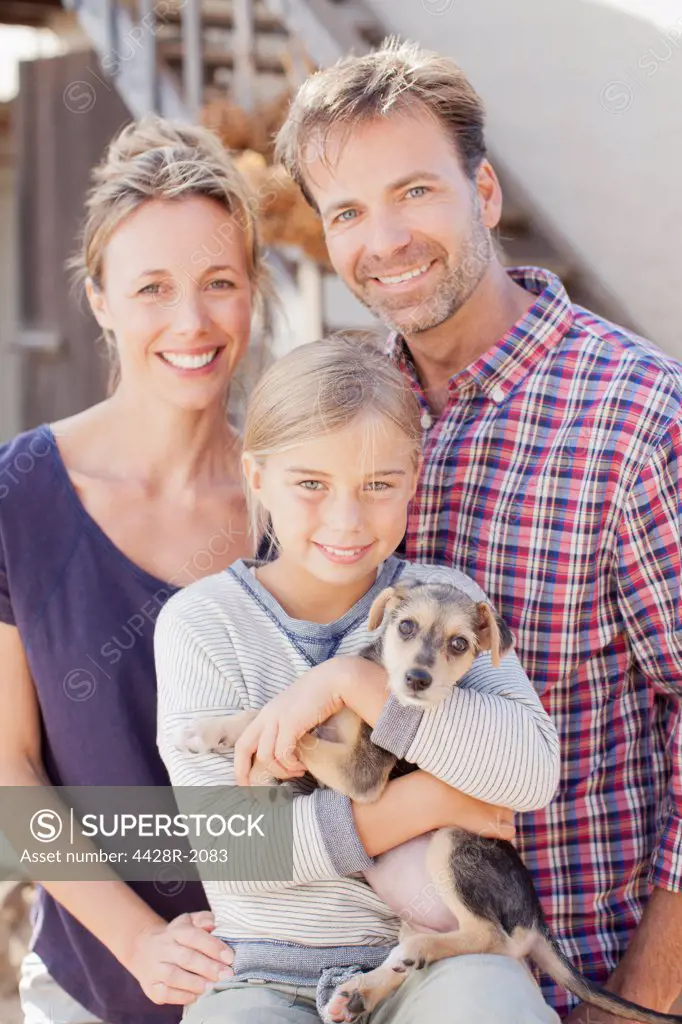 Cape Town, South Africa, Portrait of smiling family holding puppy
