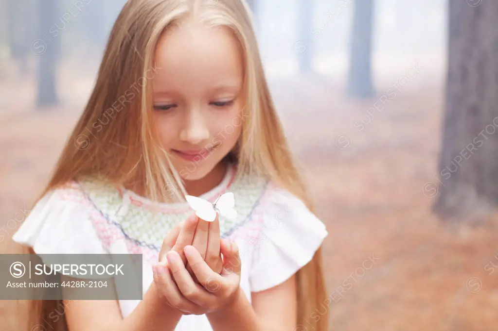 Cape Town, South Africa, Close up of girl holding butterfly in woods