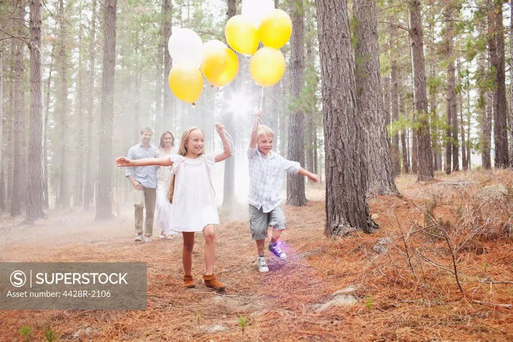 Cape Town, South Africa, Happy family with balloons in woods