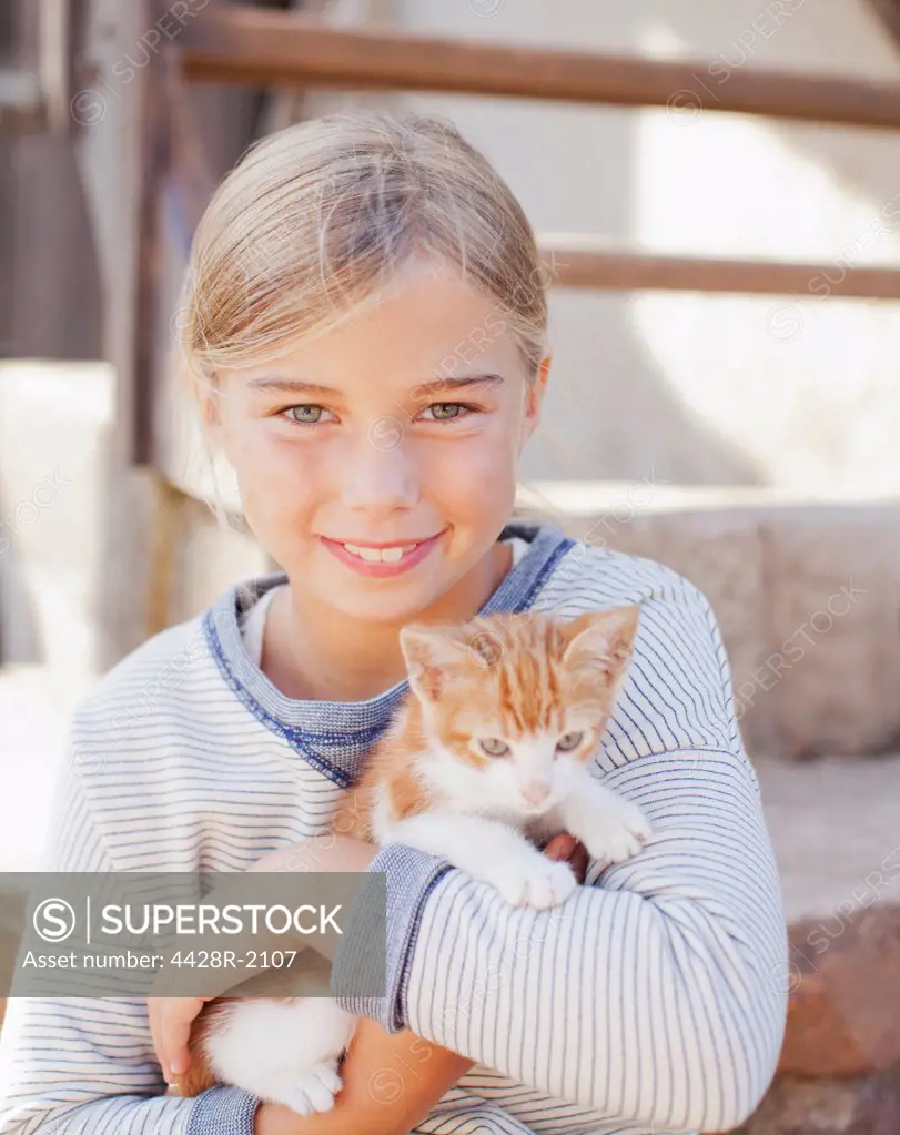 Cape Town, South Africa, Portrait of smiling girl holding kitten