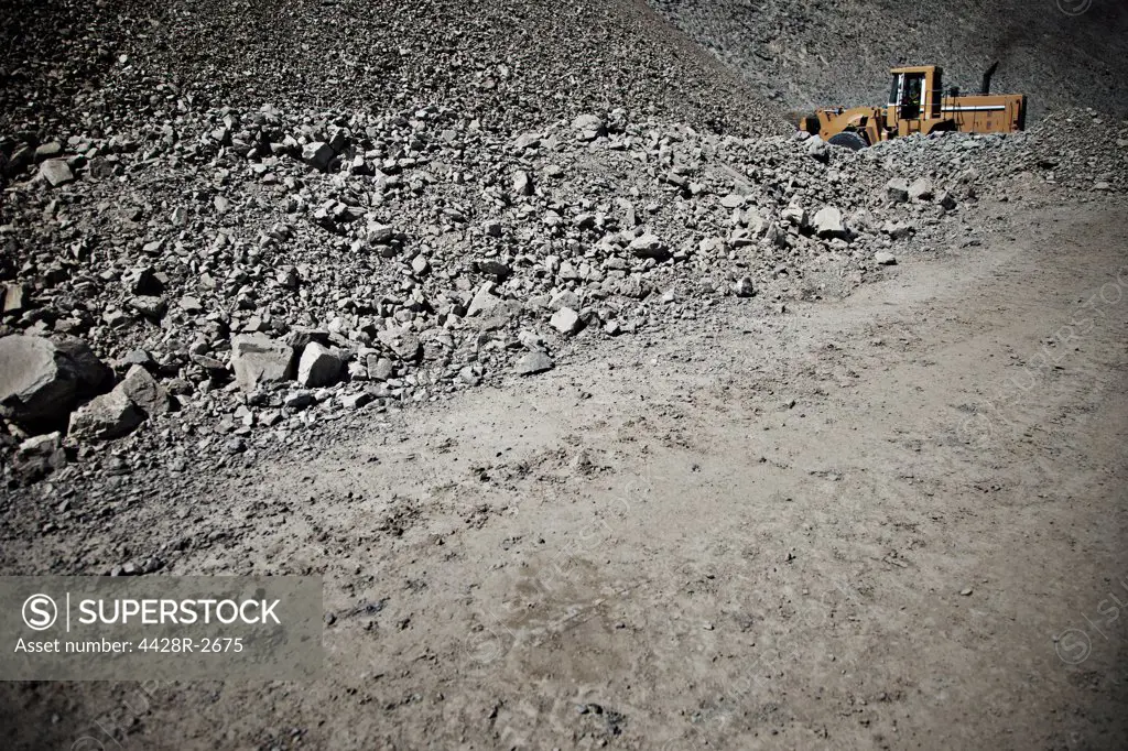 Digger driving in quarry, Spain