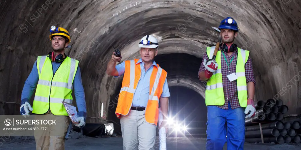 Businessman and workers walking in tunnel, Spain