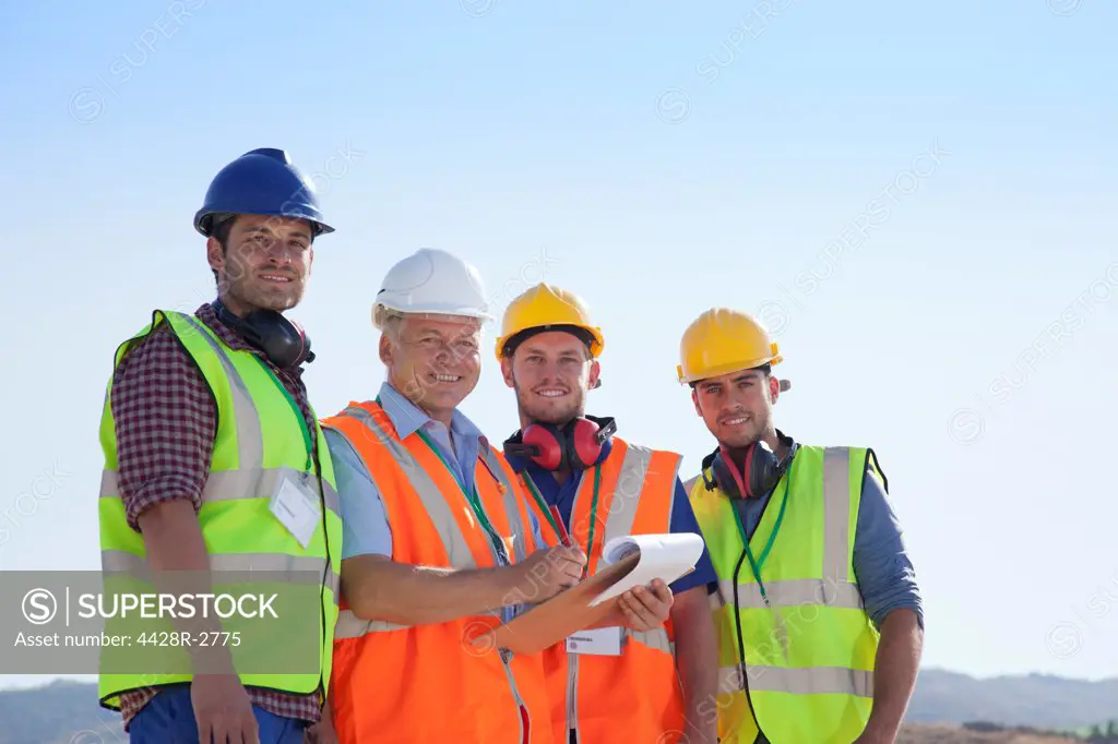 Businessman and workers smiling on site, Spain