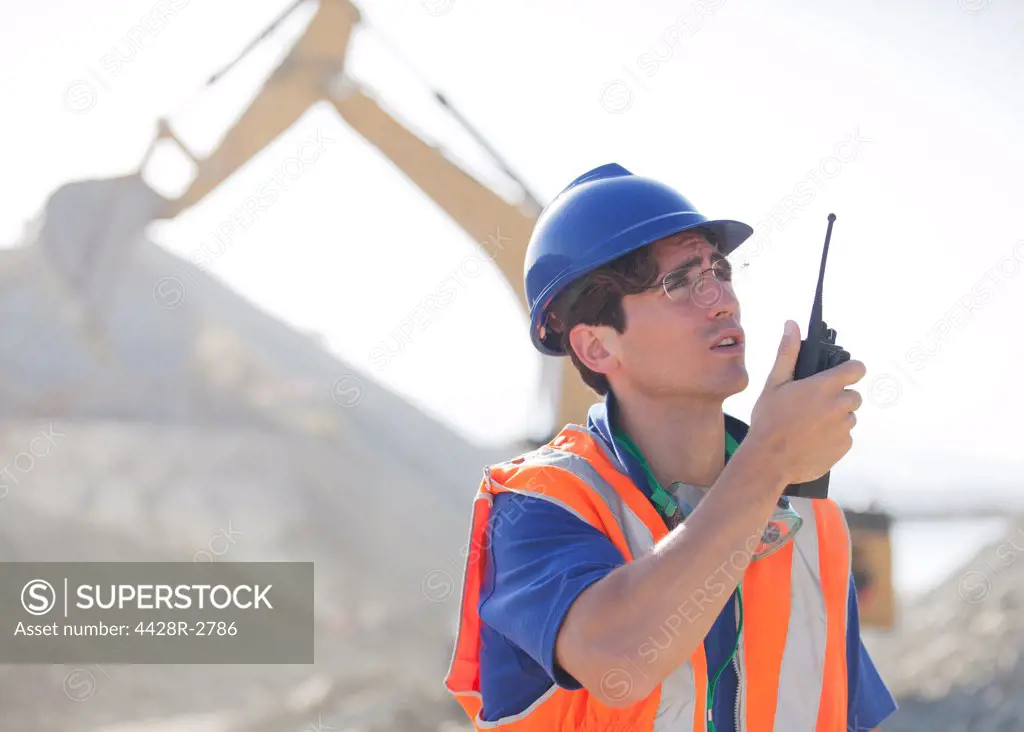 Worker using walkie-talkie in quarry, Spain