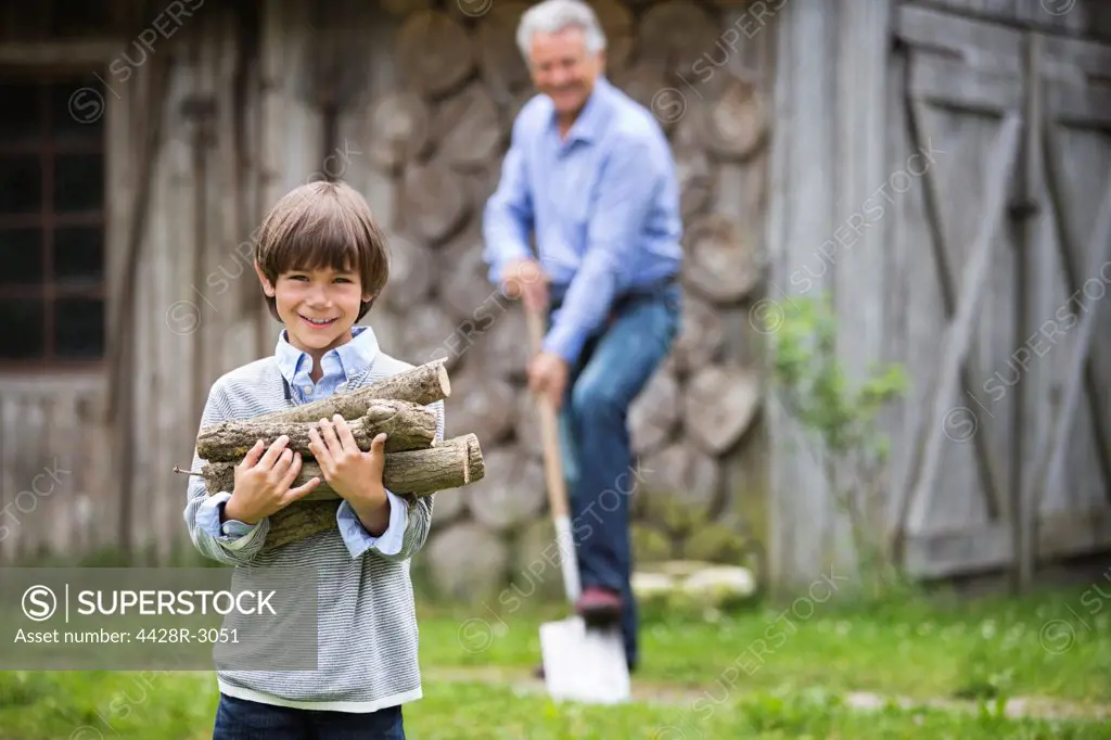 Boy carrying pile of firewood outdoors,Hamburg, Germany