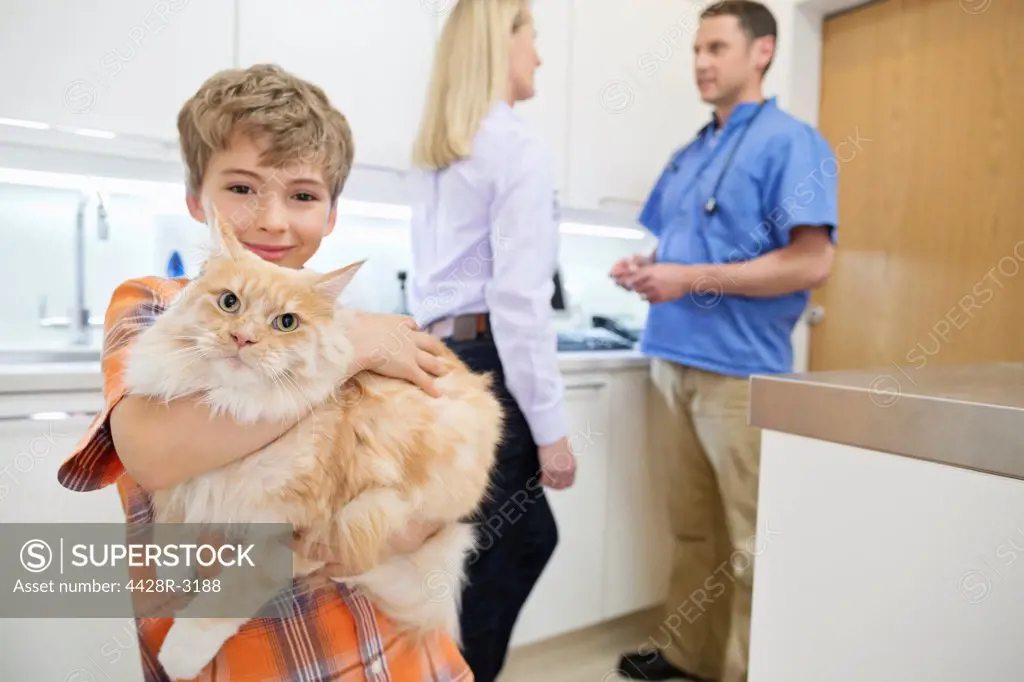 Owner holding cat in vet's surgery,London, UK