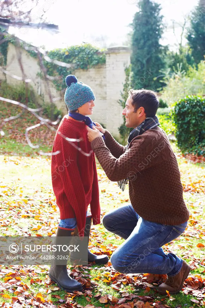 Father tying son's scarf outdoors,belmonthouse, UK