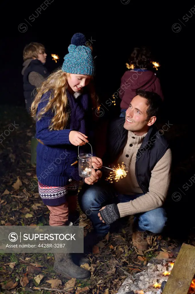 Father and daughter playing with sparkler,belmonthouse, UK