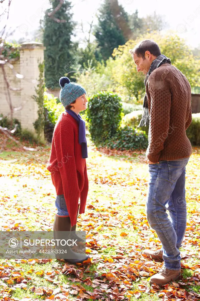 Father and son walking in autumn leaves,belmonthouse, UK