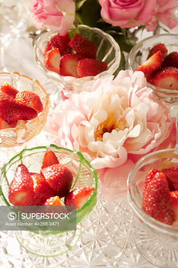 Bowls of strawberries and flowers on table,belmonthouse, UK