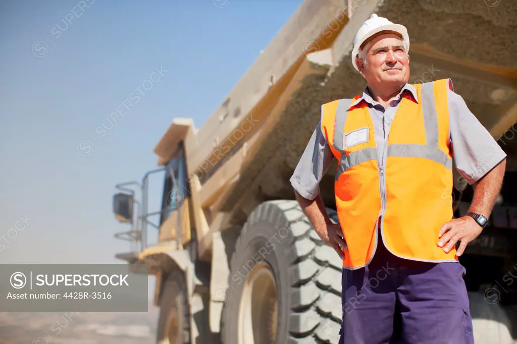 Worker standing by machinery on site, Spain